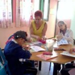 maestra voluntaria da clase a niños con discapacidad en escuela inclusiva